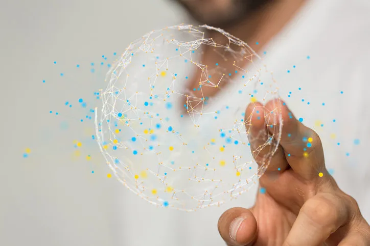 Ein Mann tippt auf eine 3D-Darstellung eines Globus mit Berührungspunkten