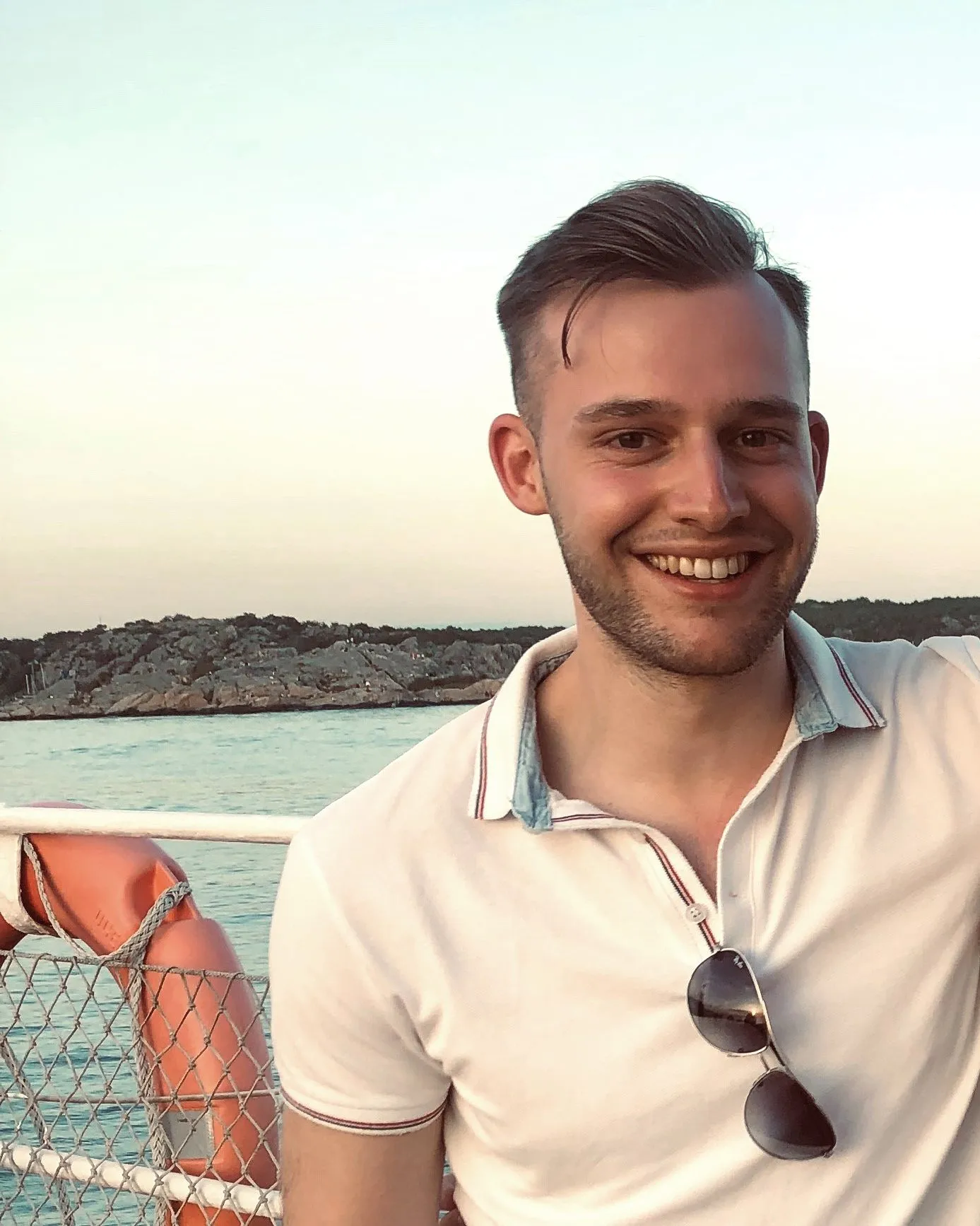 Freizeitbild von Berater Daniel Radtke auf einem Boot im Meer bei Sonnenuntergang