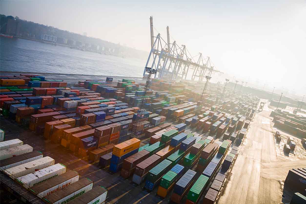 Beschaffung von Konsumgütern durch Schifffahrt. Containerterminal am Hafen mit sortierten Container, die bereit stehen zum Verladen.