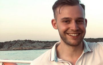 Freizeitbild von Berater Daniel Radtke auf einem Boot im Meer bei Sonnenuntergang