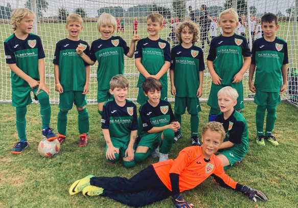 Mannschaftsfoto der lachenden Mini-Kicker des Bielefelder Fußballvereins TuS Dornberg 02 e.V. mit ihren neuen Trikots des Sponsors Prof. Roll & Pastuch.