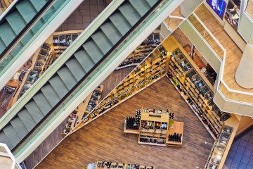 Innensicht von Oben auf ein Einkaufszentrum, man sieht Rolltreppen und Verkaufsfläche