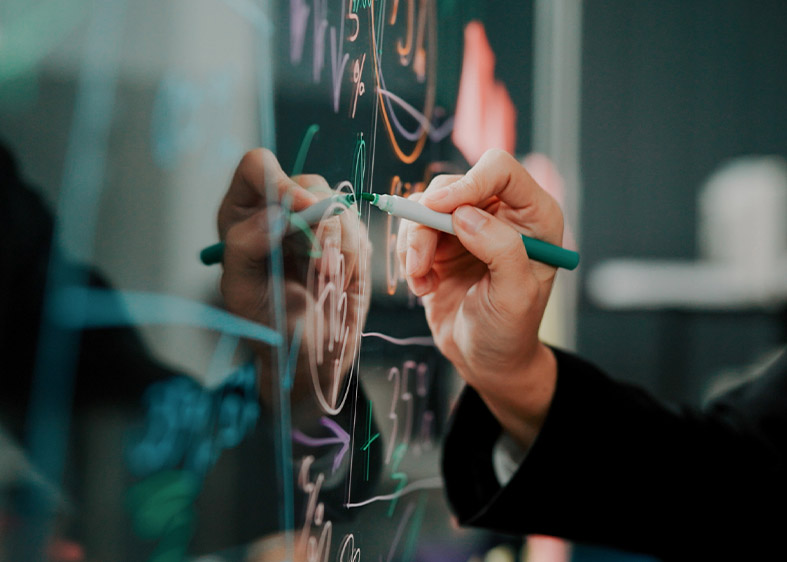 Eine Person schreibt auf eine Glastafel