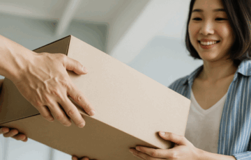 Eine junge Frau nimmt ein Paket entgegen