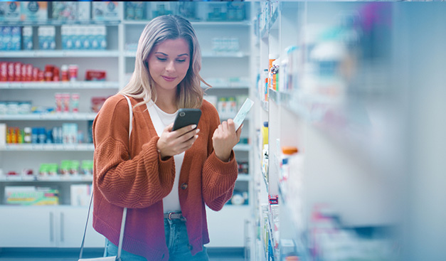 Frau beim Einkaufen im Geschäft am Smartphone